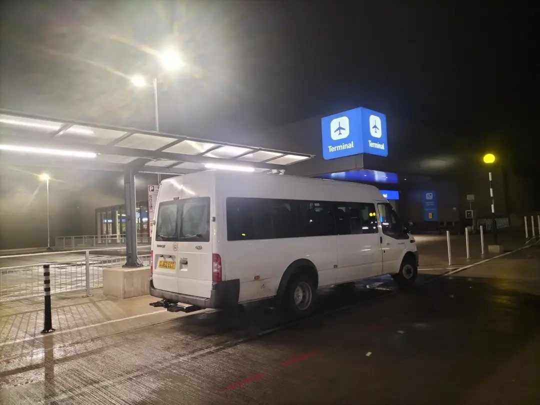AM2PM Travel minibus waiting outside the airport terminal late at night